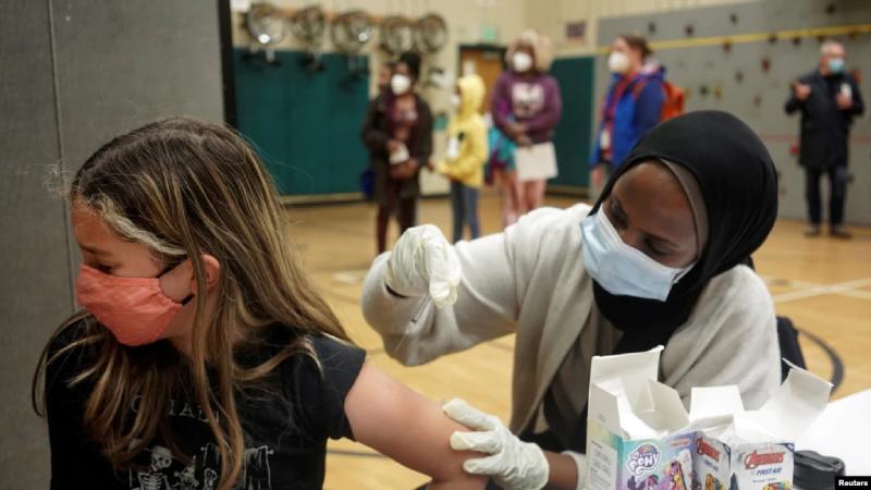 Ione Thompson, de 10 años, recibe la primera dosis de la vacuna contra la enfermedad del coronavirus Pfizer-BioNTech (COVID-19) de Iman Yunis de la farmacia Othello Station, durante una clínica de día escolar de las Escuelas Públicas de Seattle. / Foto: Reuters.