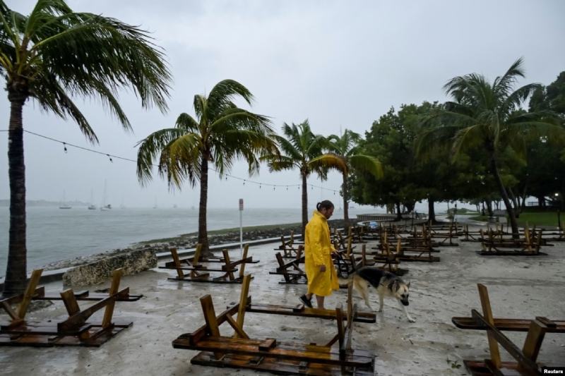 Un hombre camina con su perro a lo largo del paseo marítimo después de revisar su velero en el campo de amarre cuando el huracán Ian se acercaba a la costa del Golfo de Florida, EEUU, el 28 de septiembre de 2022. / Foto: Reuters.
